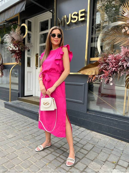 Woman in a pink dress standing in front of a building with 'MUSE' signage.