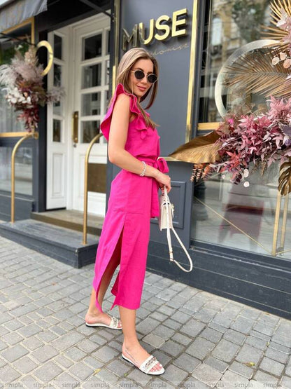 Woman in a bright pink dress standing in front of a building with 'MUSE' on the door.