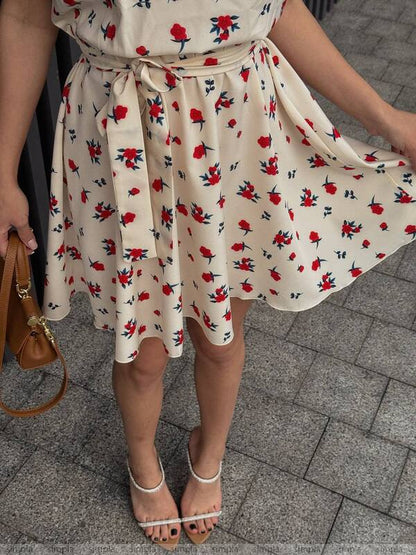 Person wearing a floral dress on a pavement background