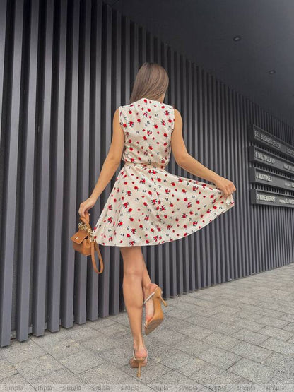 Woman in a floral dress twirling in front of a modern building.