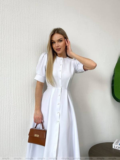 Woman wearing a white dress against a plain background