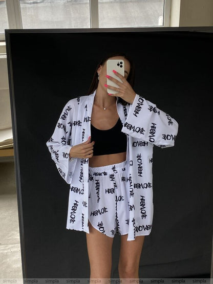 Person wearing a white kimono-style garment with black text in front of a mirror.