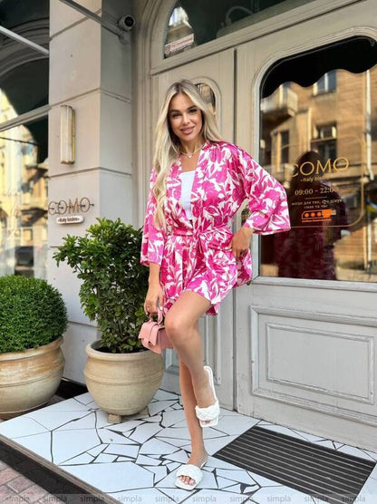 Woman in a pink and white outfit standing outside a building with 'COMO' branding.