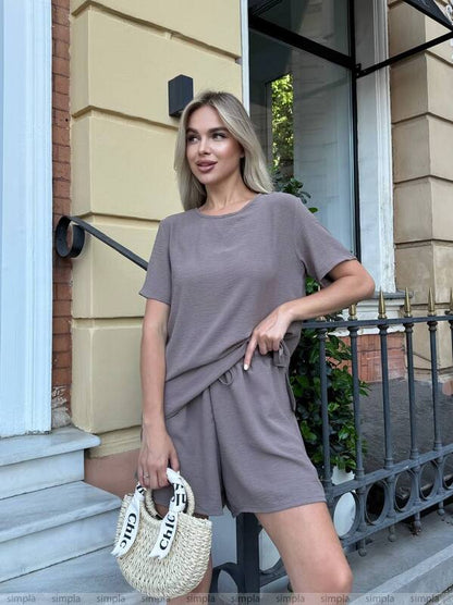Woman in a gray dress standing outside a building