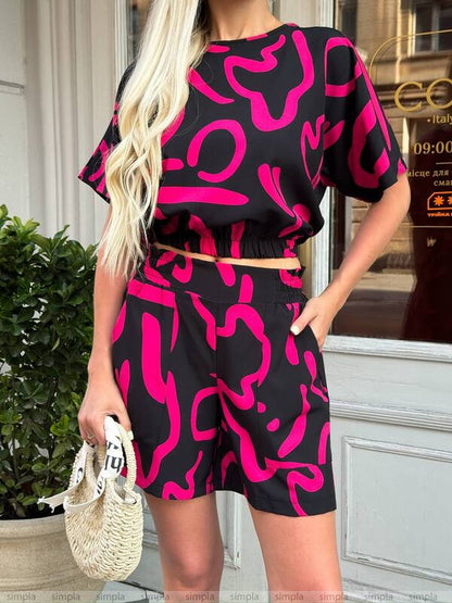 Person wearing a black and pink patterned outfit standing outdoors.