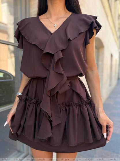 Woman wearing a brown ruffled dress on a blurred street background