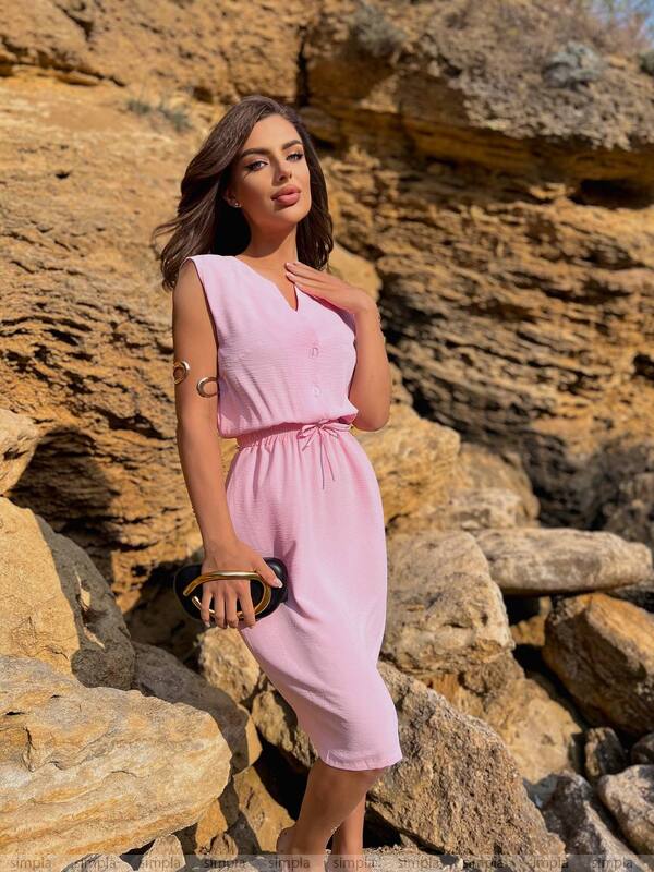 Woman in a pink dress standing on rocky terrain
