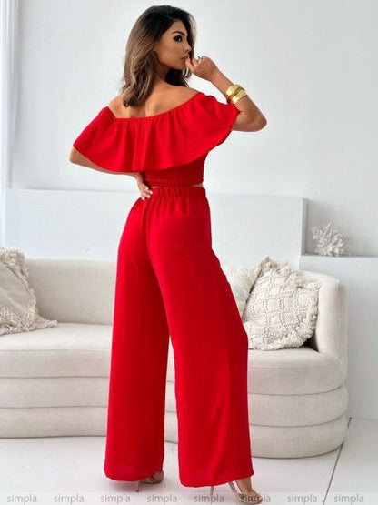 Woman wearing a red jumpsuit in a living room setting