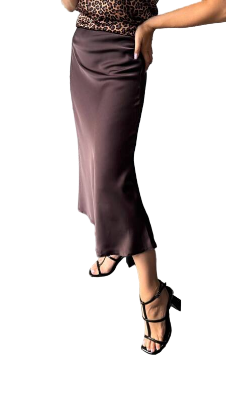 Person wearing a brown satin skirt with leopard print waistband on a white background