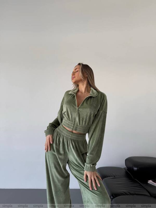 Woman wearing a green tracksuit against a plain background