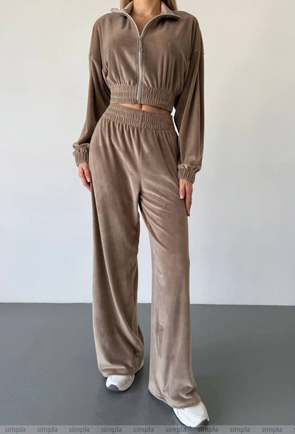 Brown tracksuit worn by a person on a plain background
