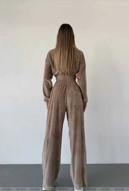 Person wearing a brown jumpsuit against a plain background