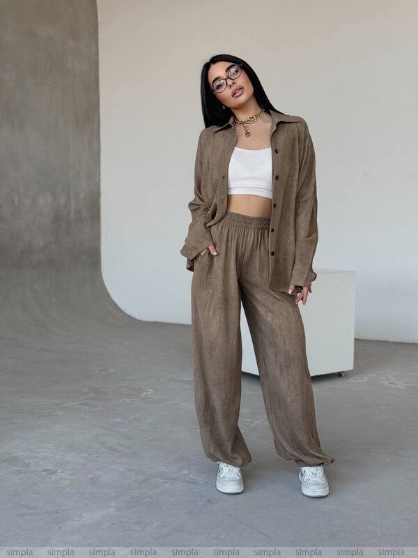 Woman wearing a brown outfit with a white top in an indoor setting