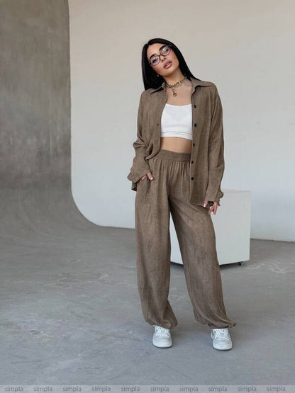 Woman wearing a brown outfit with a white top in an indoor setting