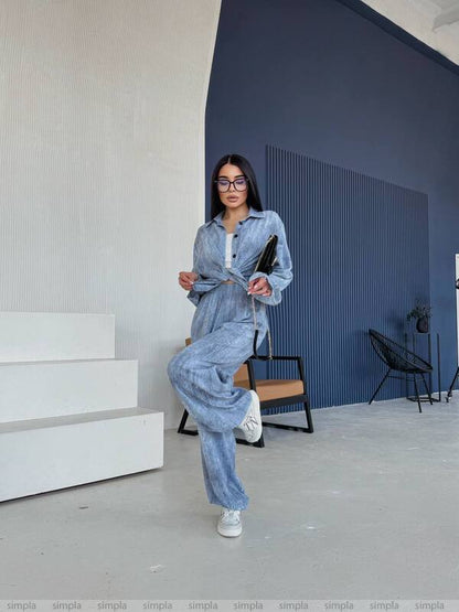 Woman in a denim outfit standing in a modern indoor setting.