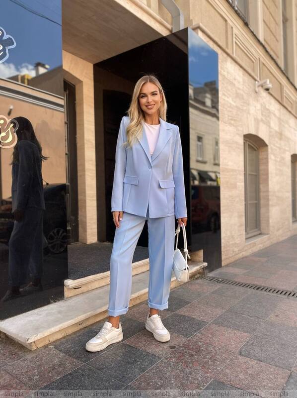 Woman in a light blue suit standing on a city street