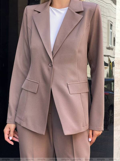 Person wearing a brown suit with a blurred background