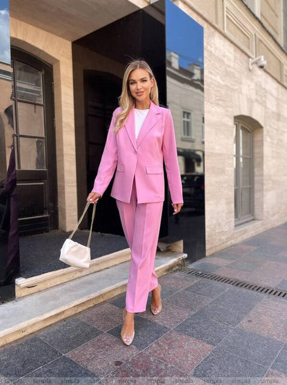 Woman in a pink suit standing outside a building