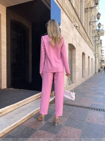 Woman in a pink suit walking down a street