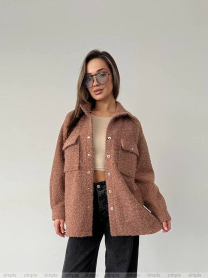 Woman wearing a brown coat against a plain background