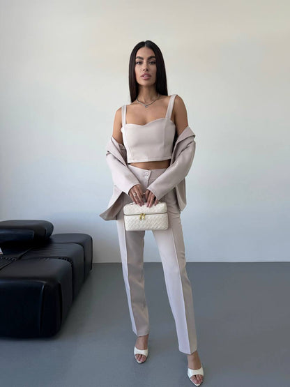 Woman in a stylish outfit with a neutral color palette in an indoor setting.