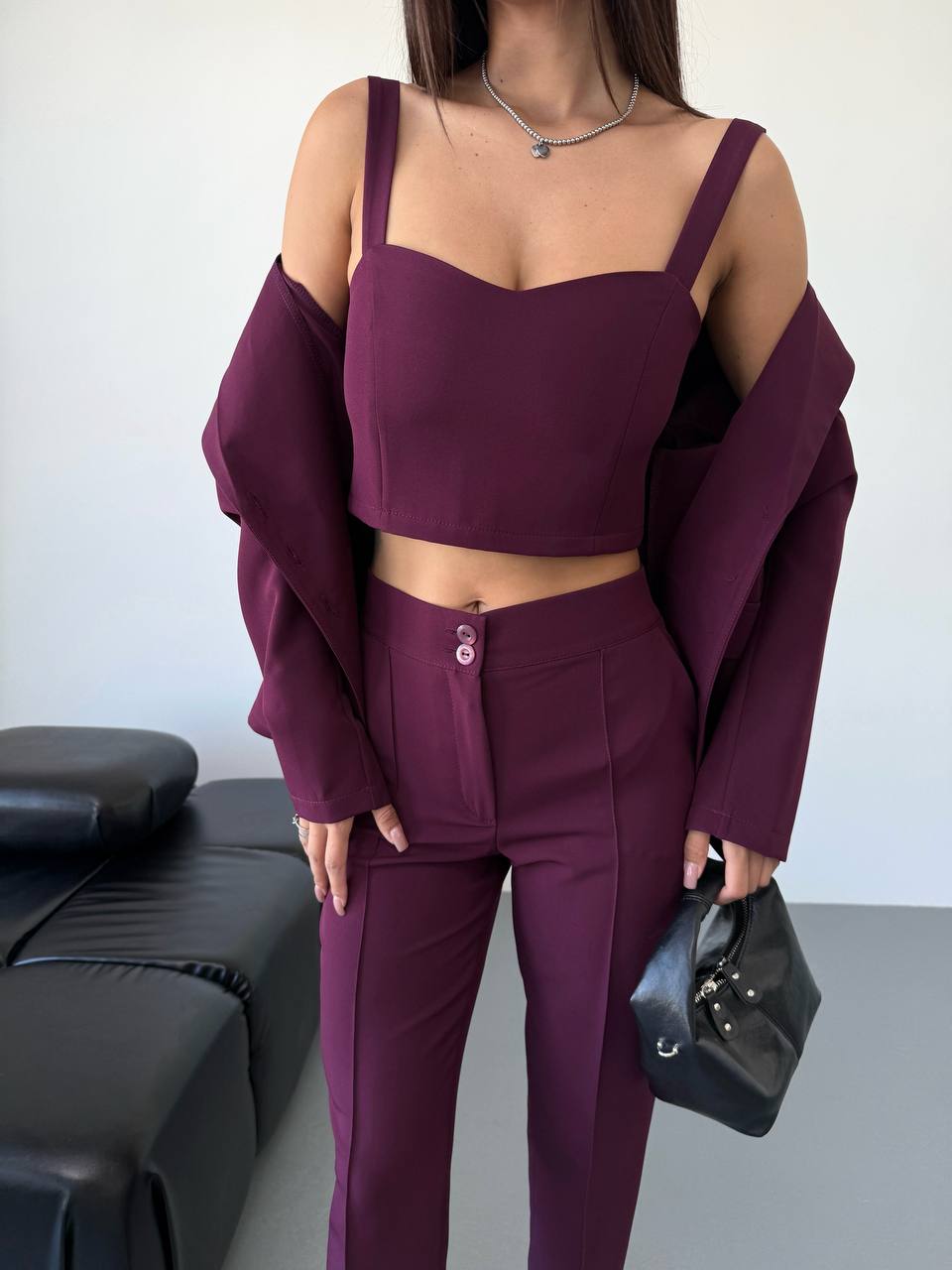 Person wearing a purple outfit with a plain background