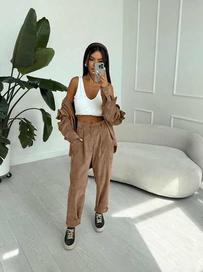 Woman taking a mirror selfie in a stylish outfit in a modern room.
