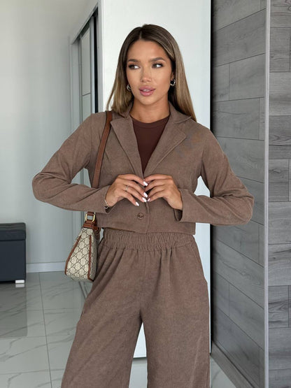 Woman in a brown outfit standing in a modern interior setting