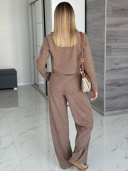 Woman in a brown outfit standing in a modern interior setting