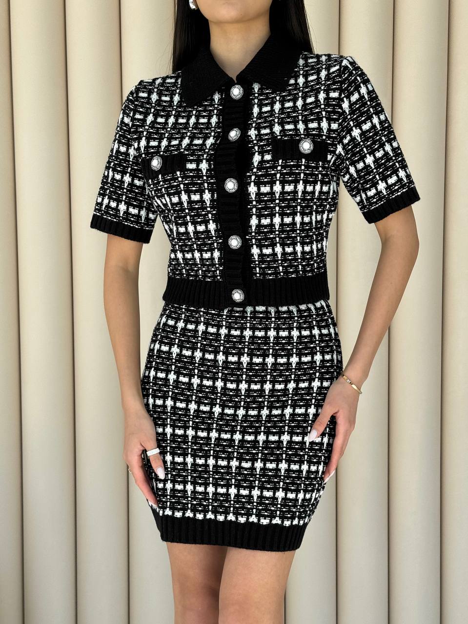 Black and white patterned dress with buttons on a neutral background