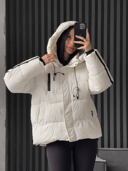 Person wearing a white puffer jacket with black accents, taking a mirror selfie.
