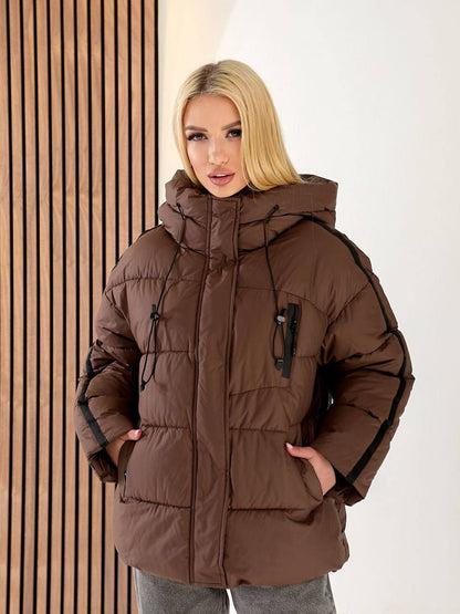 Woman wearing a brown winter coat with a neutral background