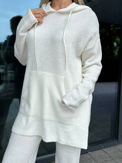 Person wearing a white hoodie and pants in an outdoor setting