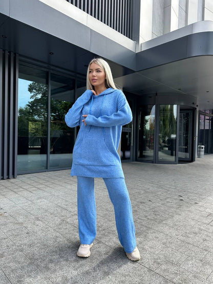 Person wearing a blue outfit standing in front of a modern building.
