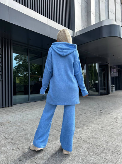 Person wearing a blue outfit walking outside a modern building.