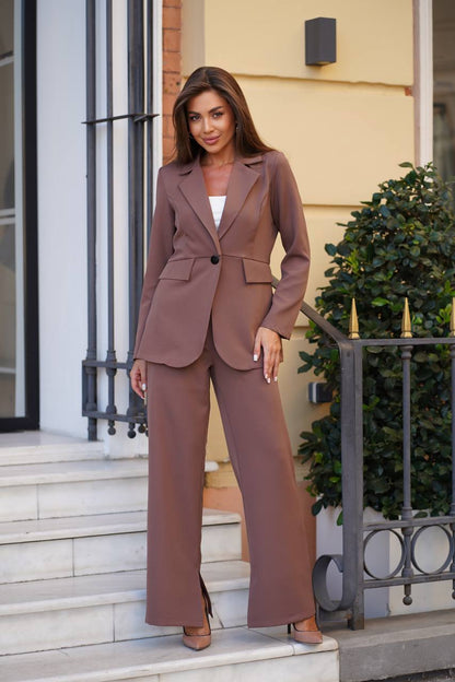 Woman in a brown suit standing on steps outside a building.
