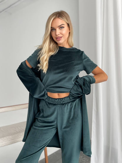 Woman wearing a teal tracksuit in a minimalistic room.