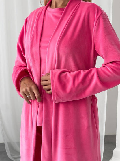 Person wearing a bright pink robe against a white background