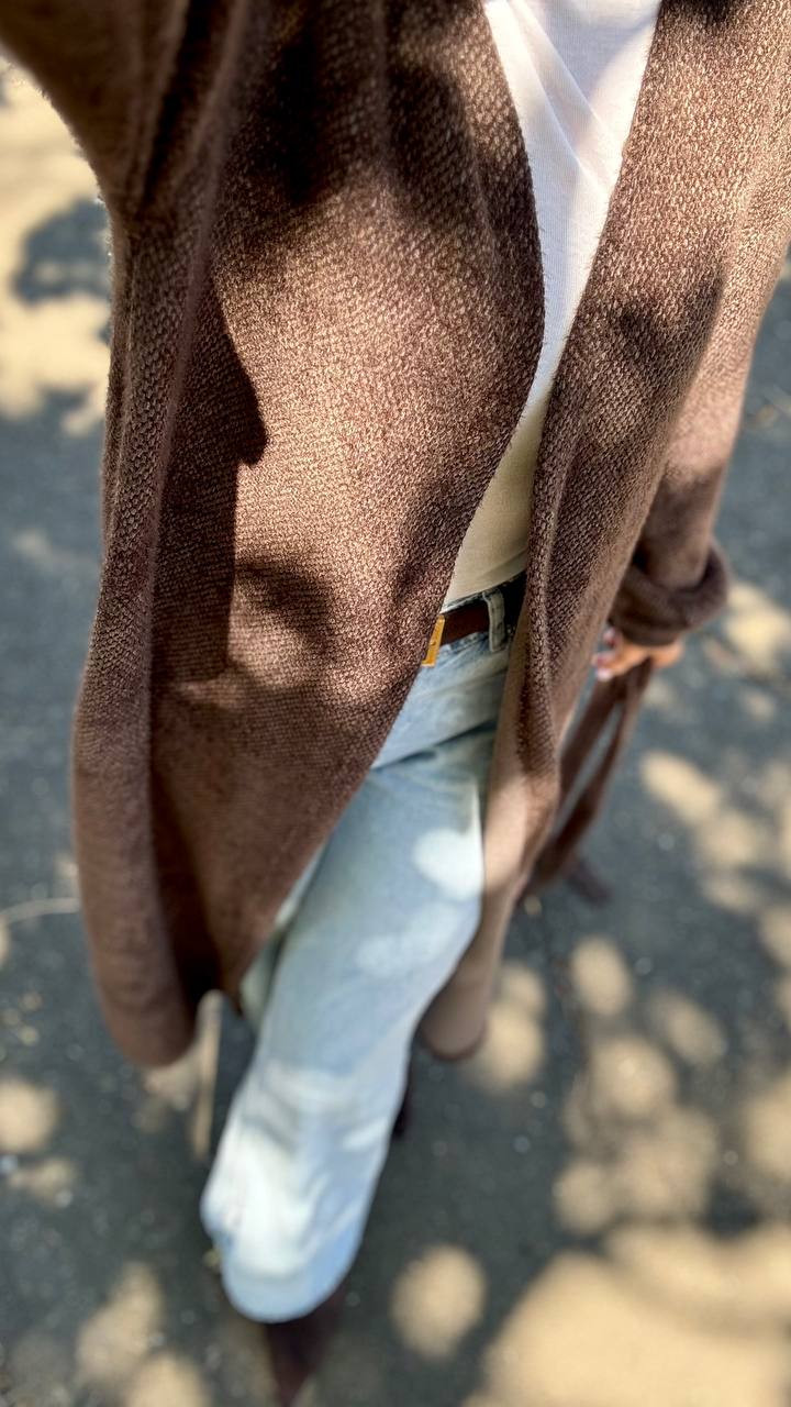 Close-up of a person wearing a brown coat with a blurred background