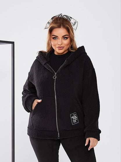 Woman wearing a black fleece jacket with a white background