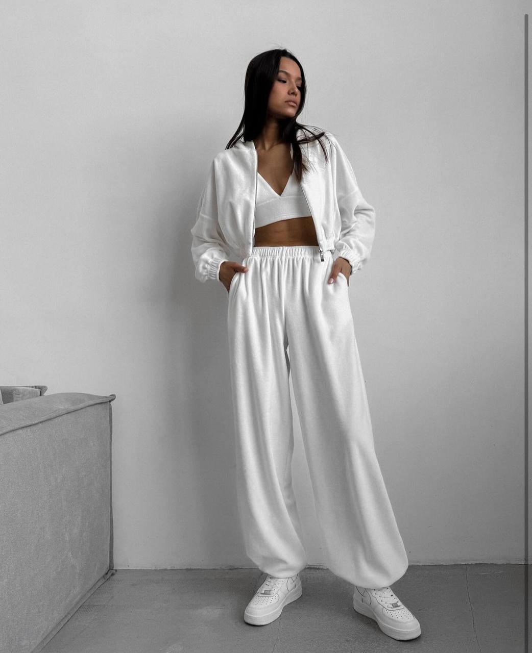 Person wearing a white outfit with a plain background
