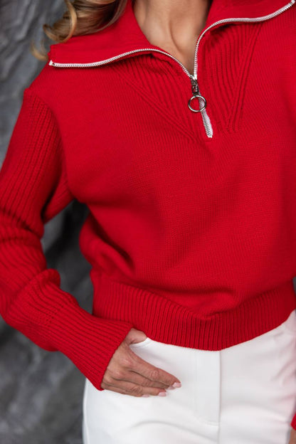 Red sweater with a zipper detail worn by a person, blurred background