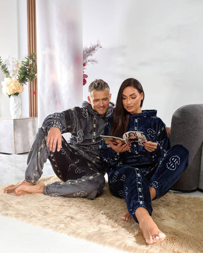 Man and woman sitting on a rug reading a magazine in a modern living room.