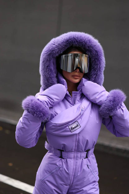Person wearing a purple snowsuit with a hood and goggles in an urban setting