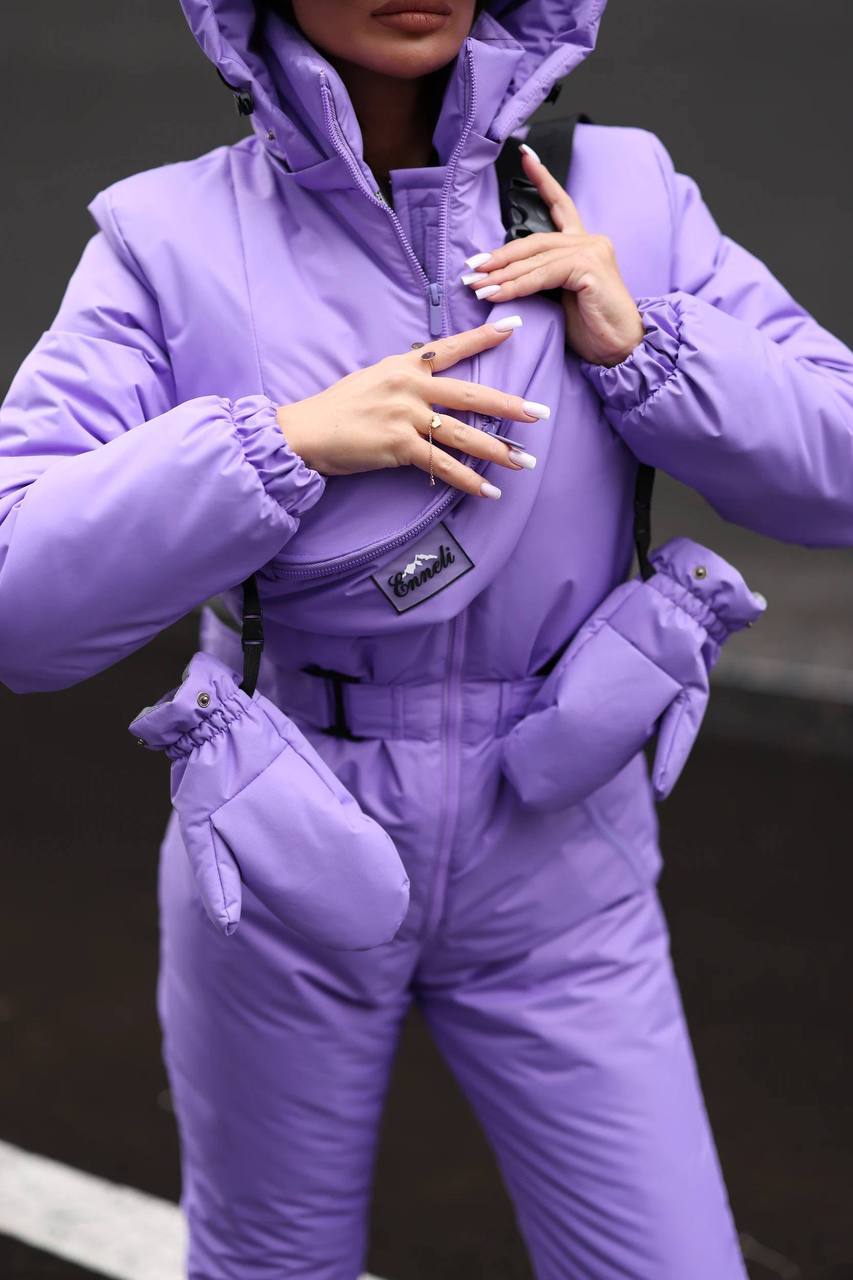 Person wearing a purple snowsuit with a hood and gloves on a dark background