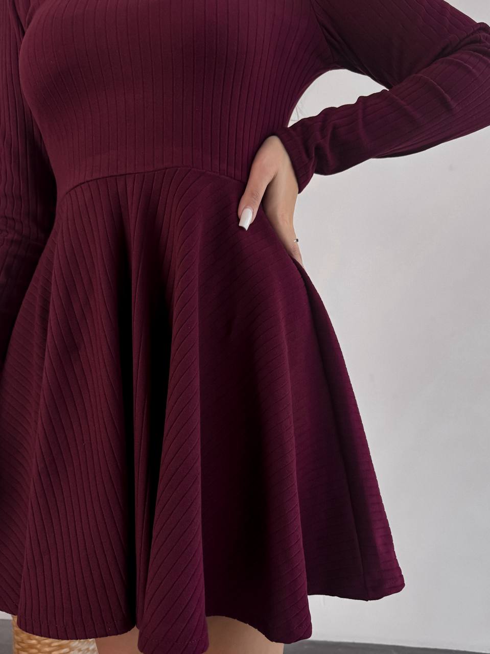 Maroon dress with long sleeves on a plain background