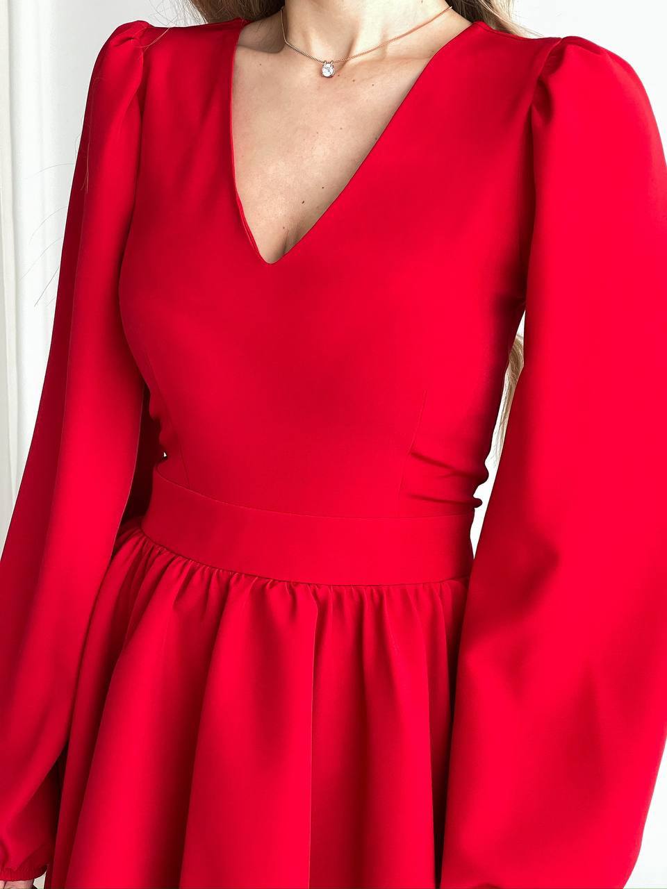 Red dress with long sleeves on a plain background