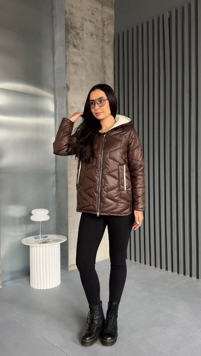 Woman wearing a brown quilted jacket in an indoor setting