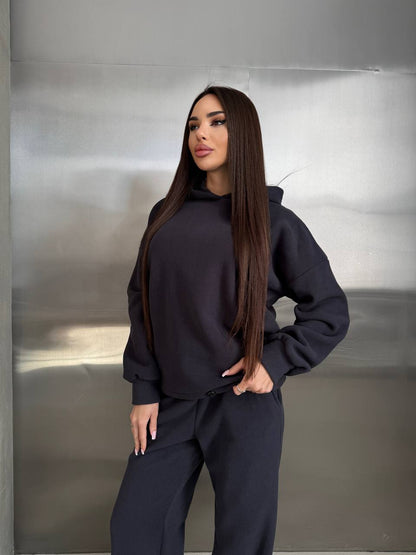 Woman wearing a black outfit against a metallic background