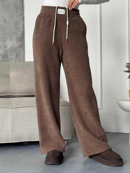 Brown pants worn by a person in a minimal indoor setting